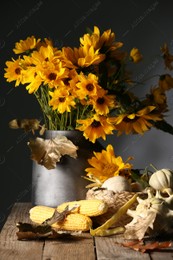 Beautiful autumn bouquet, small pumpkins and corn cobs on wooden table against dark grey background Photo of Beautiful autumn bouquet, small pumpkins and corn cobs on wooden table against dark grey background