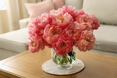Beautiful pink peonies in vase on table at home. Interior design Photo of Beautiful pink peonies in vase on table at home. Interior design