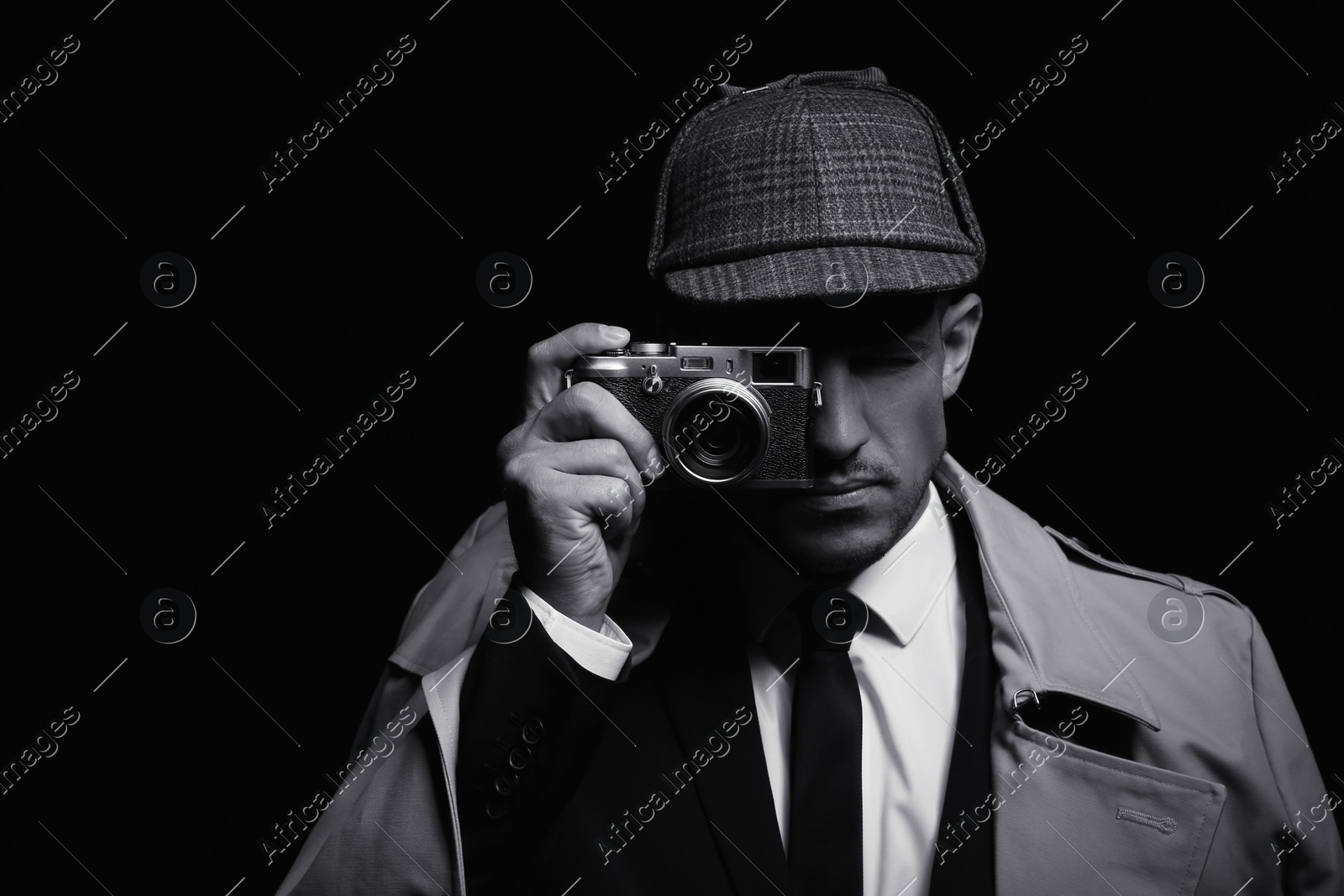 Old fashioned detective with camera on dark background, black and white effect Photo of Old fashioned detective with camera on dark background, black and white effect