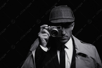 Old fashioned detective with camera on dark background, black and white effect Photo of Old fashioned detective with camera on dark background, black and white effect