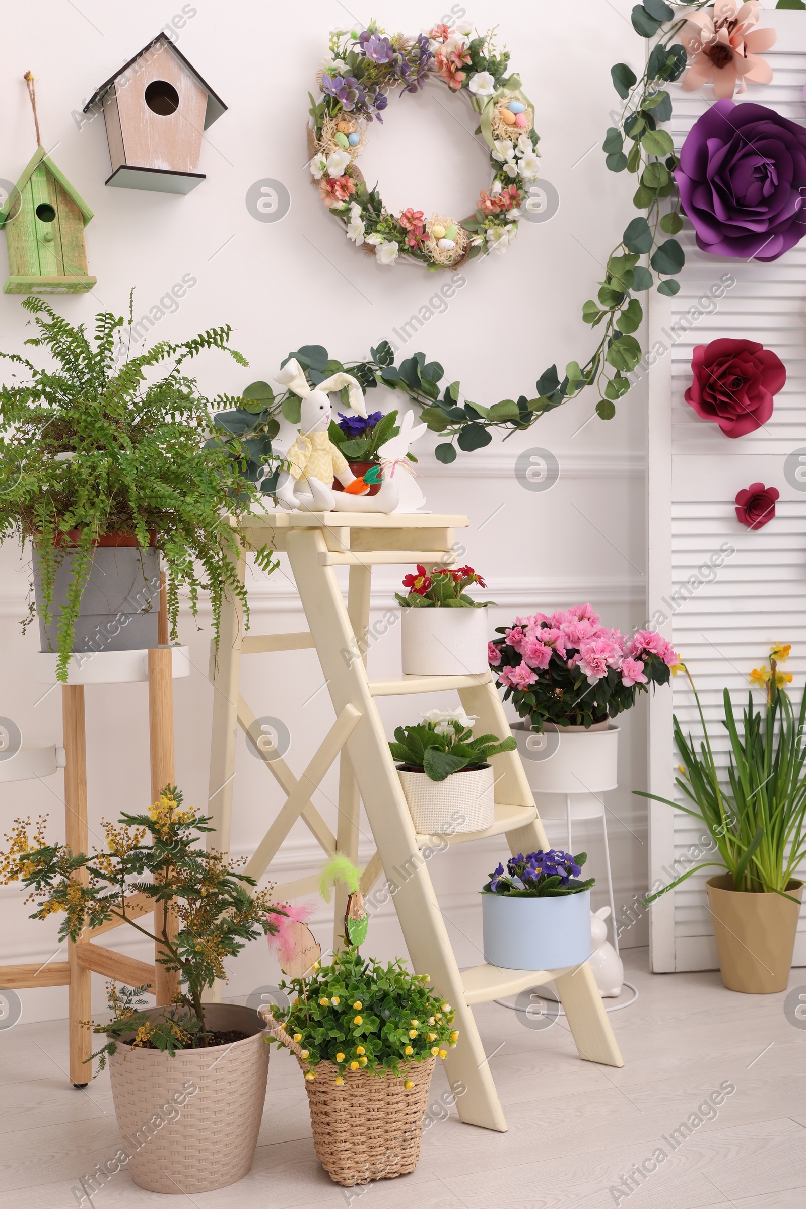 Easter photo zone with plants and paper flowers indoors Photo of Easter photo zone with plants and paper flowers indoors