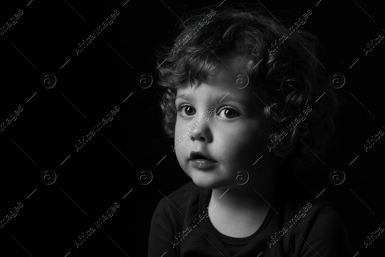 Portrait of cute little boy on dark background, space for text. Black and white effect Photo of Portrait of cute little boy on dark background, space for text. Black and white effect