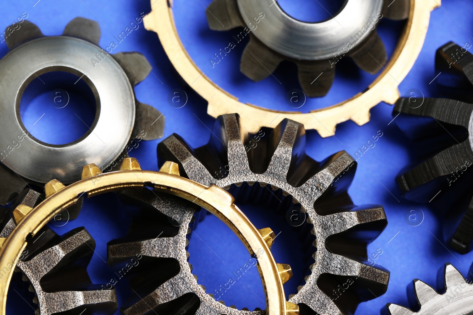 Different stainless steel gears on light blue background, closeup Photo of Different stainless steel gears on light blue background, closeup