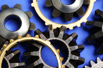 Different stainless steel gears on light blue background, closeup Photo of Different stainless steel gears on light blue background, closeup