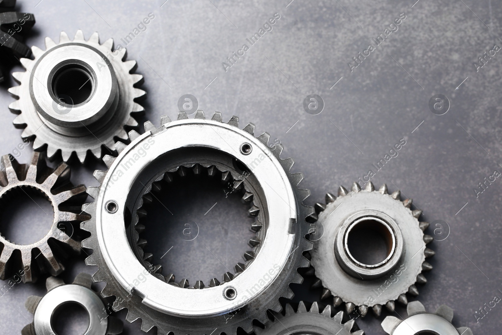 Different stainless steel gears on grey background, flat lay. Space for text Photo of Different stainless steel gears on grey background, flat lay. Space for text