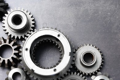 Different stainless steel gears on grey background, flat lay. Space for text Photo of Different stainless steel gears on grey background, flat lay. Space for text