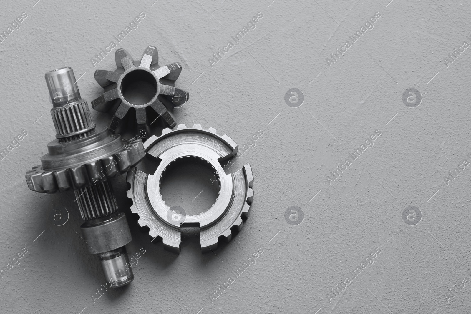 Different stainless steel gears on grey background, flat lay. Space for text Photo of Different stainless steel gears on grey background, flat lay. Space for text