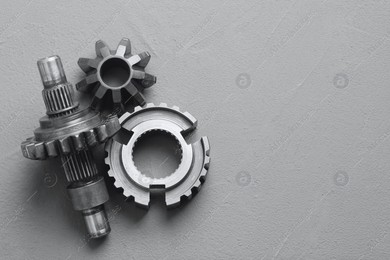 Different stainless steel gears on grey background, flat lay. Space for text Photo of Different stainless steel gears on grey background, flat lay. Space for text