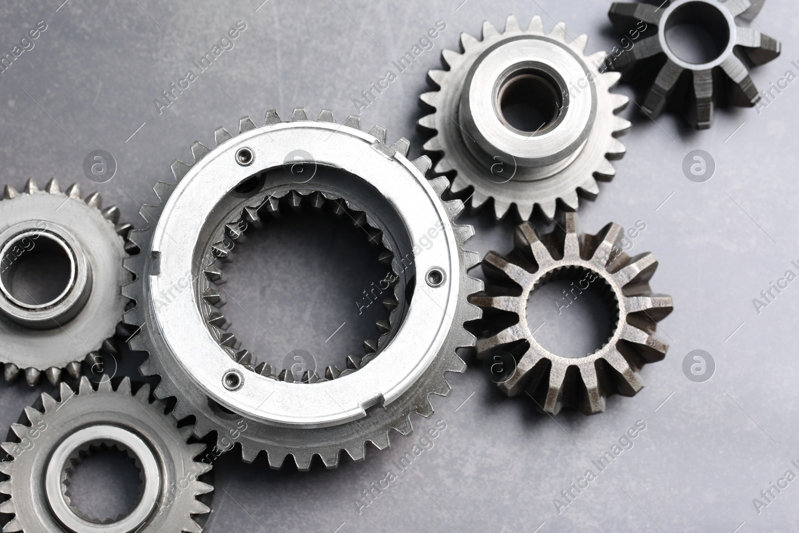Different stainless steel gears on grey background, flat lay Photo of Different stainless steel gears on grey background, flat lay