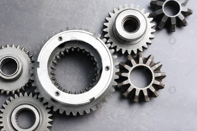 Different stainless steel gears on grey background, flat lay Photo of Different stainless steel gears on grey background, flat lay