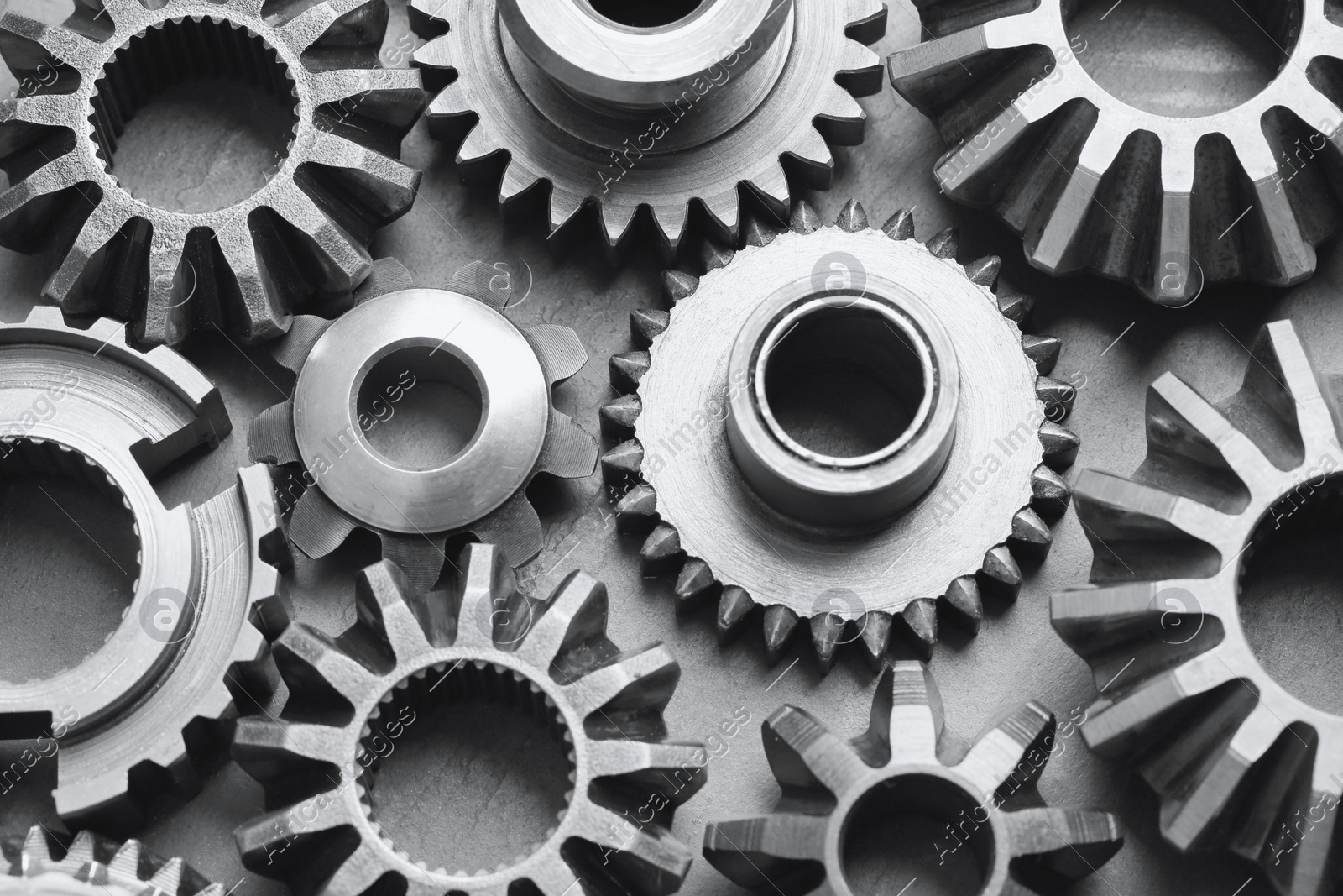 Many different stainless steel gears on grey background, above view Photo of Many different stainless steel gears on grey background, above view
