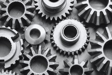 Many different stainless steel gears on grey background, above view Photo of Many different stainless steel gears on grey background, above view