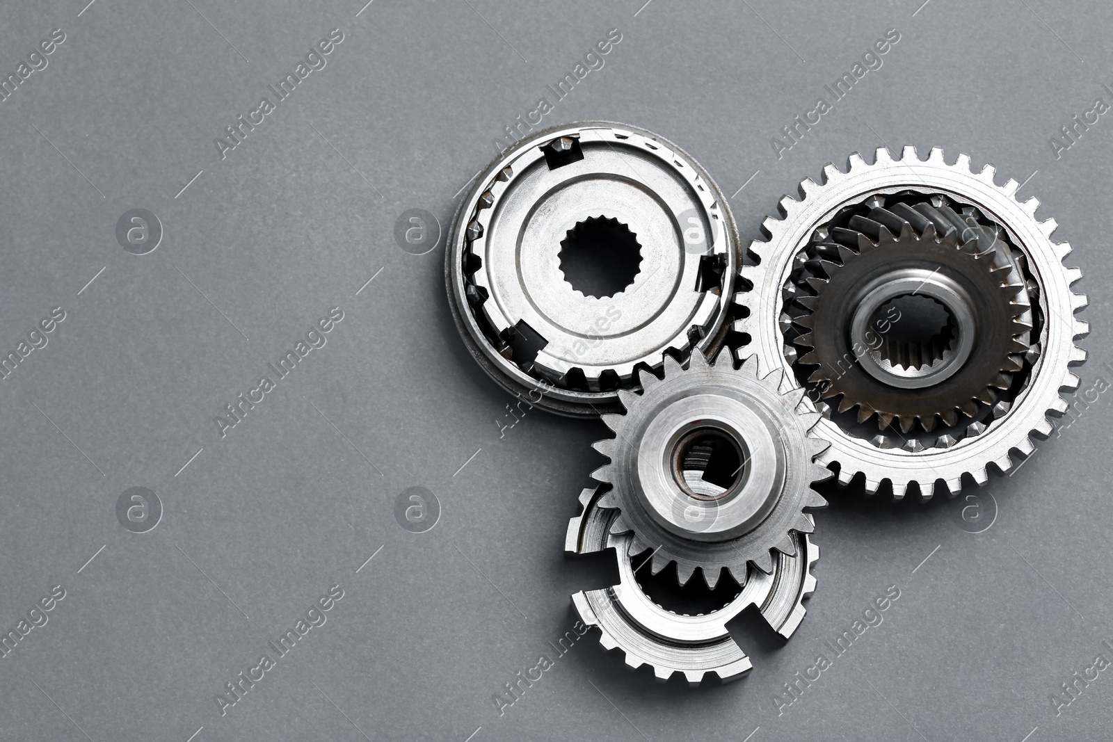 Different stainless steel gears on grey background, flat lay. Space for text Photo of Different stainless steel gears on grey background, flat lay. Space for text