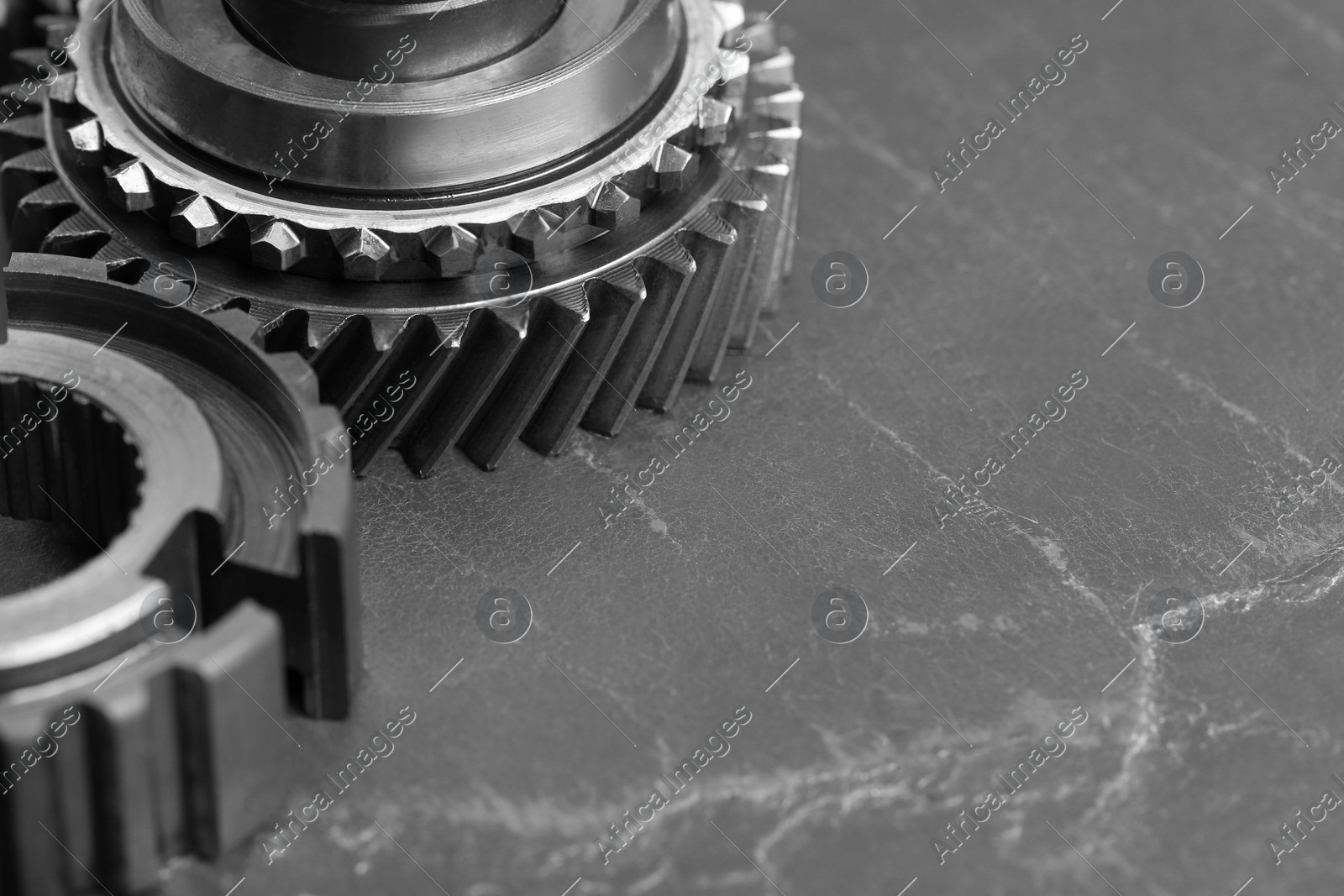 Different stainless steel gears on grey background, closeup. Space for text Photo of Different stainless steel gears on grey background, closeup. Space for text