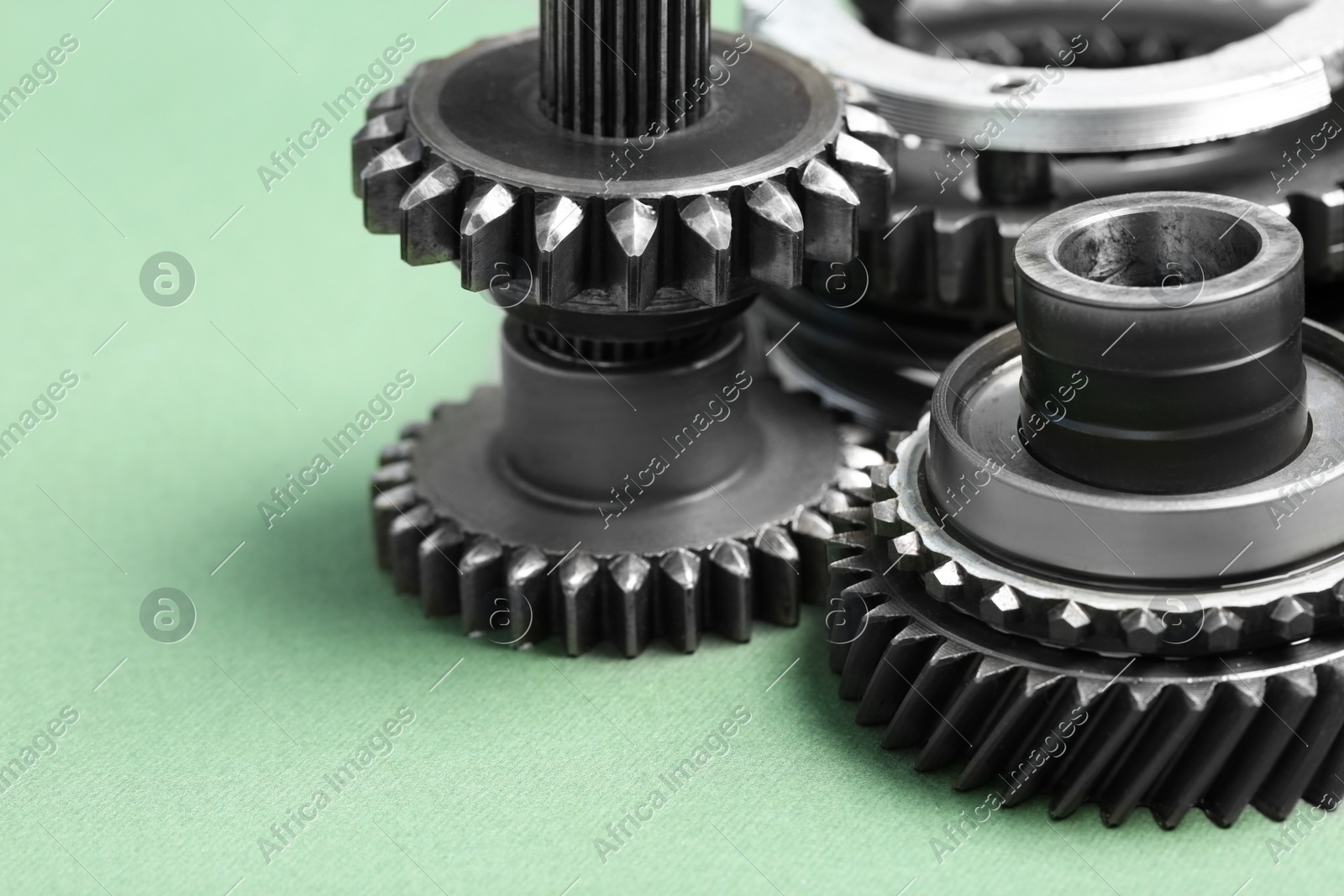 Different stainless steel gears on light green background, closeup Photo of Different stainless steel gears on light green background, closeup