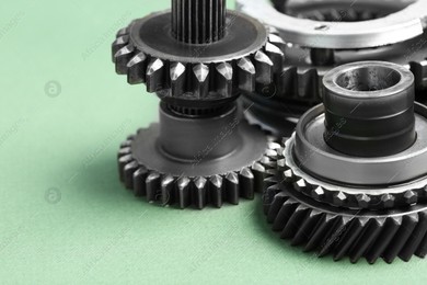 Different stainless steel gears on light green background, closeup Photo of Different stainless steel gears on light green background, closeup