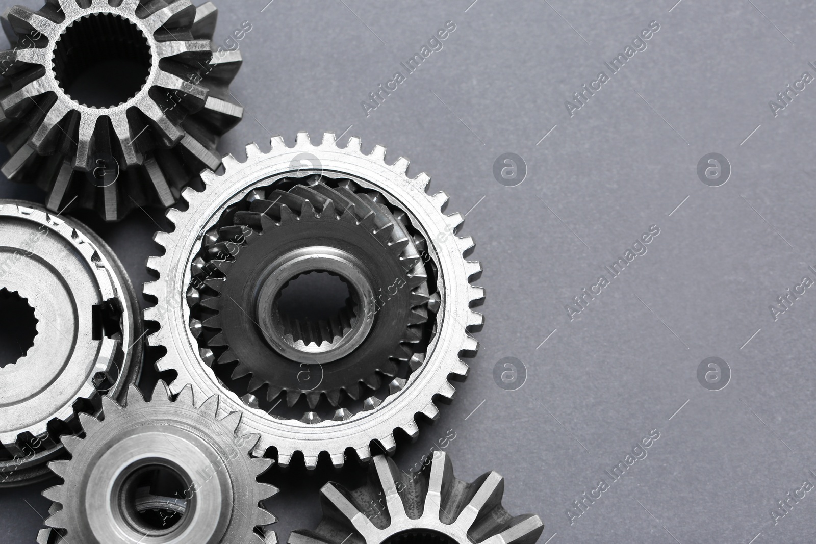 Many different stainless steel gears on grey background, flat lay. Space for text Photo of Many different stainless steel gears on grey background, flat lay. Space for text