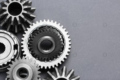 Many different stainless steel gears on grey background, flat lay. Space for text Photo of Many different stainless steel gears on grey background, flat lay. Space for text