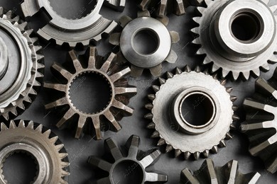 Many different stainless steel gears on grey background, flat lay Photo of Many different stainless steel gears on grey background, flat lay