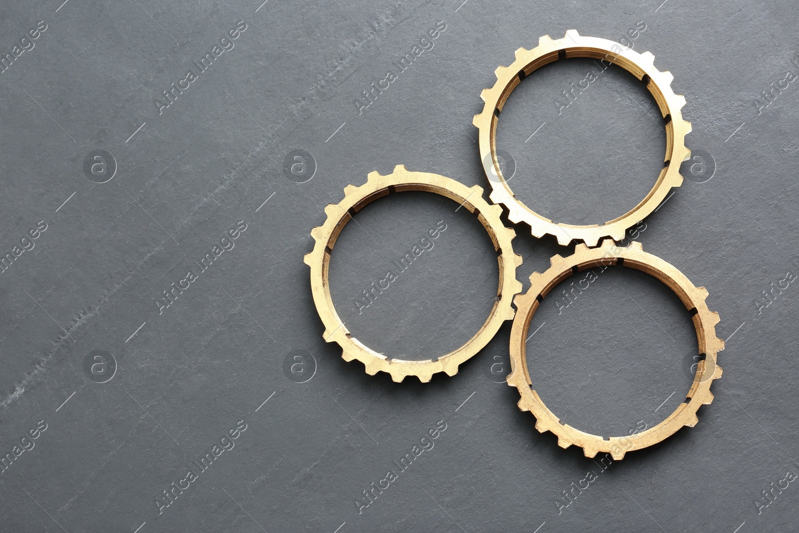 Stainless steel gears on grey background, flat lay. Space for text Photo of Stainless steel gears on grey background, flat lay. Space for text