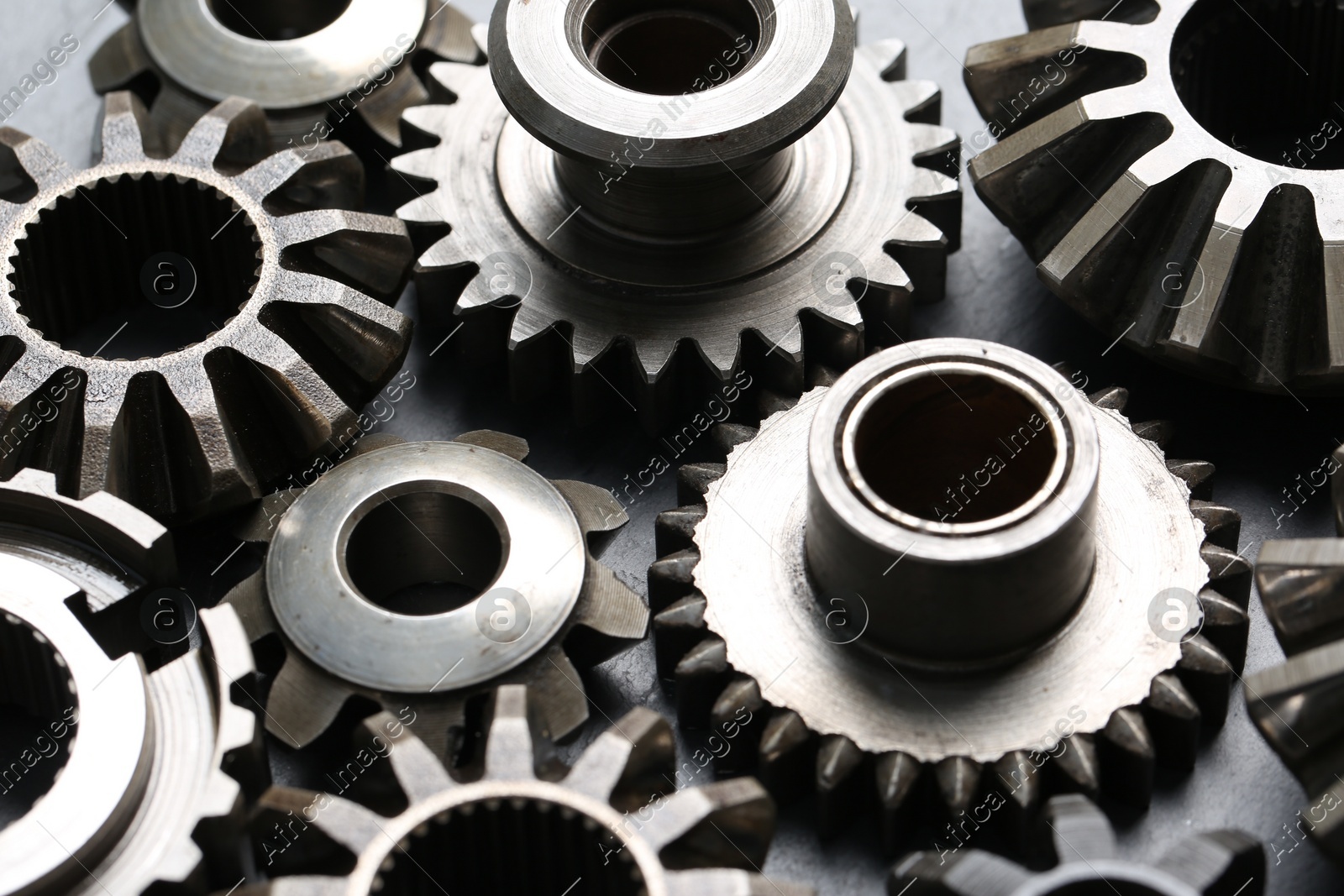 Many different stainless steel gears on grey background, closeup Photo of Many different stainless steel gears on grey background, closeup