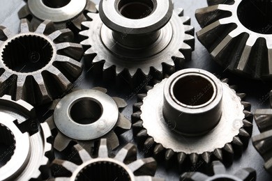 Many different stainless steel gears on grey background, closeup Photo of Many different stainless steel gears on grey background, closeup