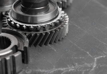 Different stainless steel gears on grey background, closeup. Space for text Photo of Different stainless steel gears on grey background, closeup. Space for text
