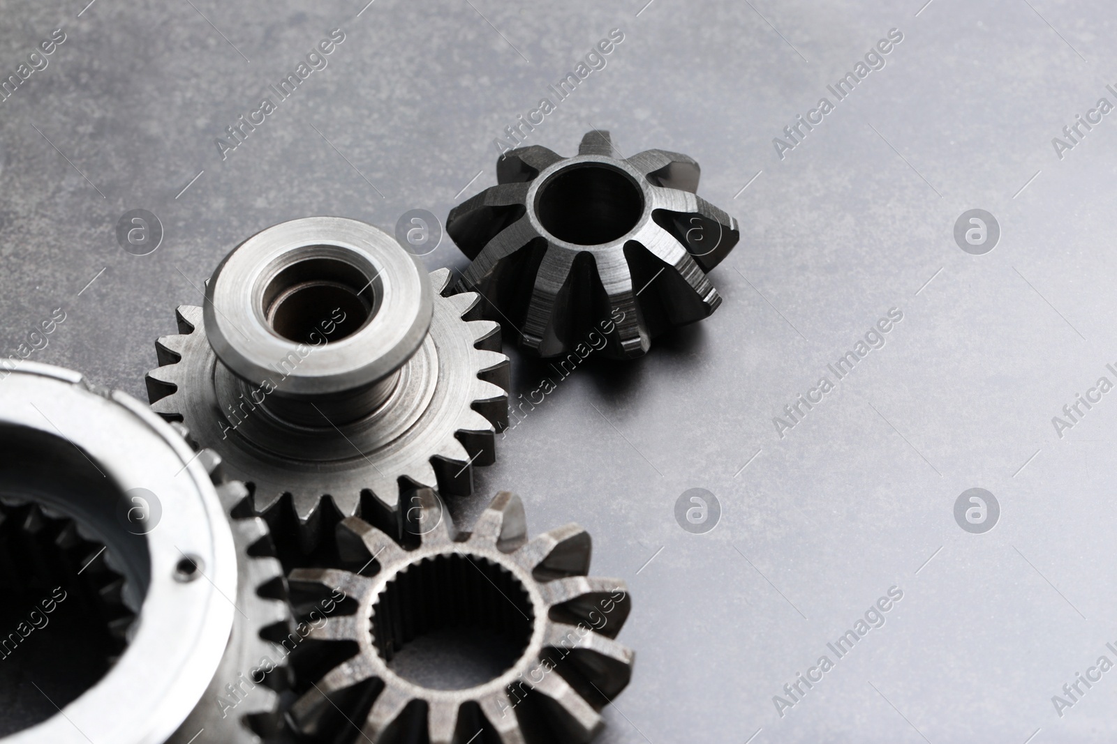 Different stainless steel gears on grey background. Space for text Photo of Different stainless steel gears on grey background. Space for text