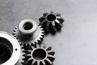 Different stainless steel gears on grey background. Space for text Photo of Different stainless steel gears on grey background. Space for text