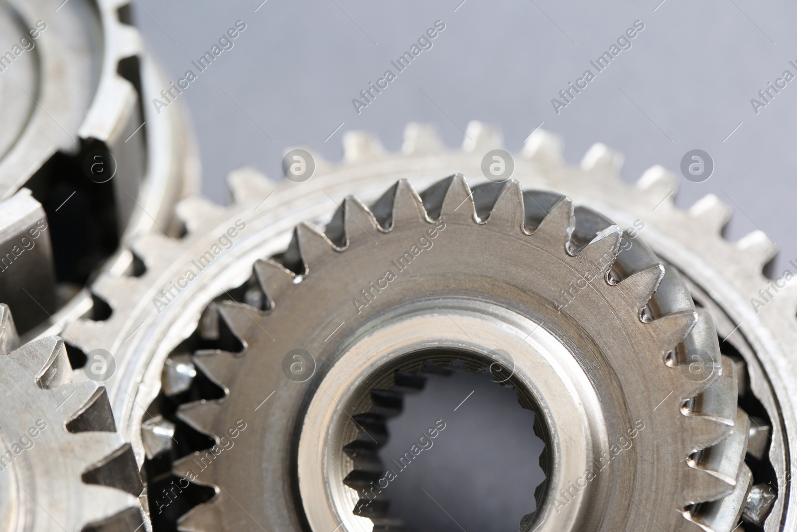 Many different stainless steel gears on grey background, closeup Photo of Many different stainless steel gears on grey background, closeup