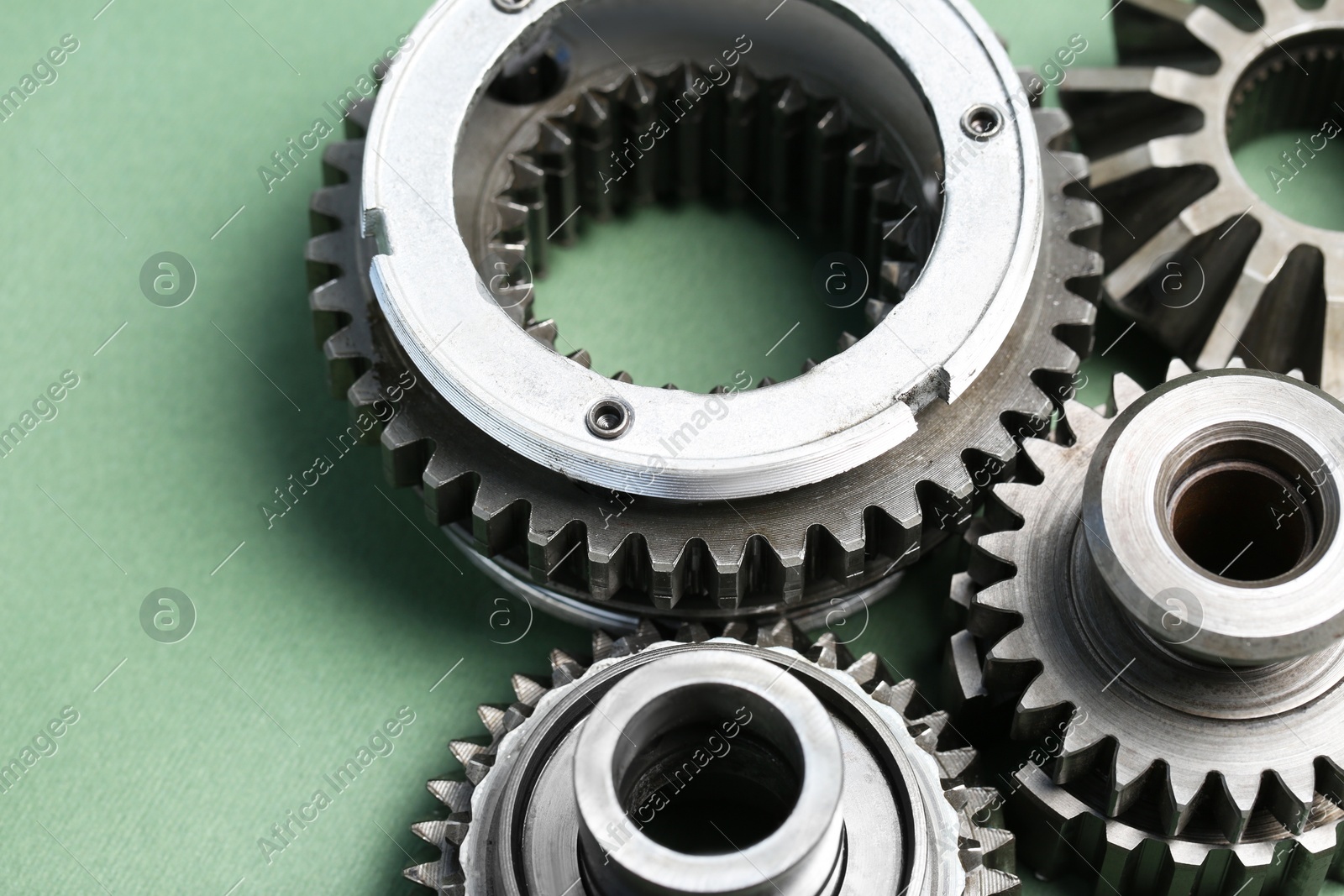 Different stainless steel gears on light green background, closeup Photo of Different stainless steel gears on light green background, closeup