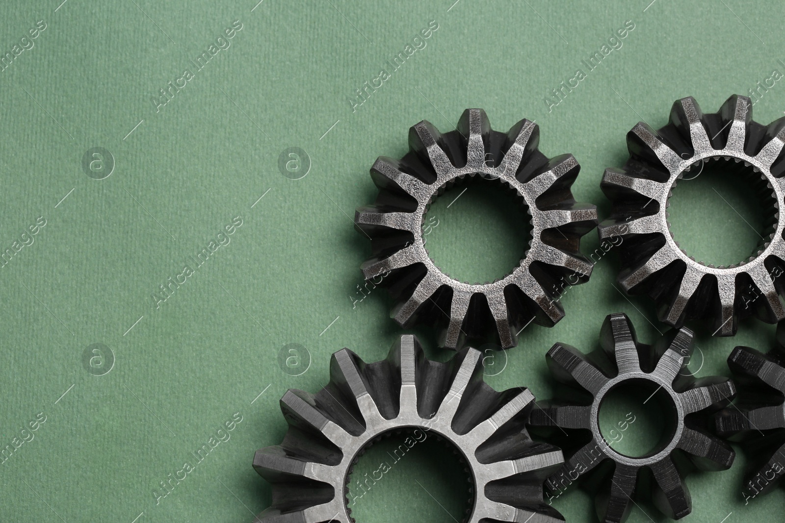 Different stainless steel gears on light green background, flat lay. Space for text Photo of Different stainless steel gears on light green background, flat lay. Space for text