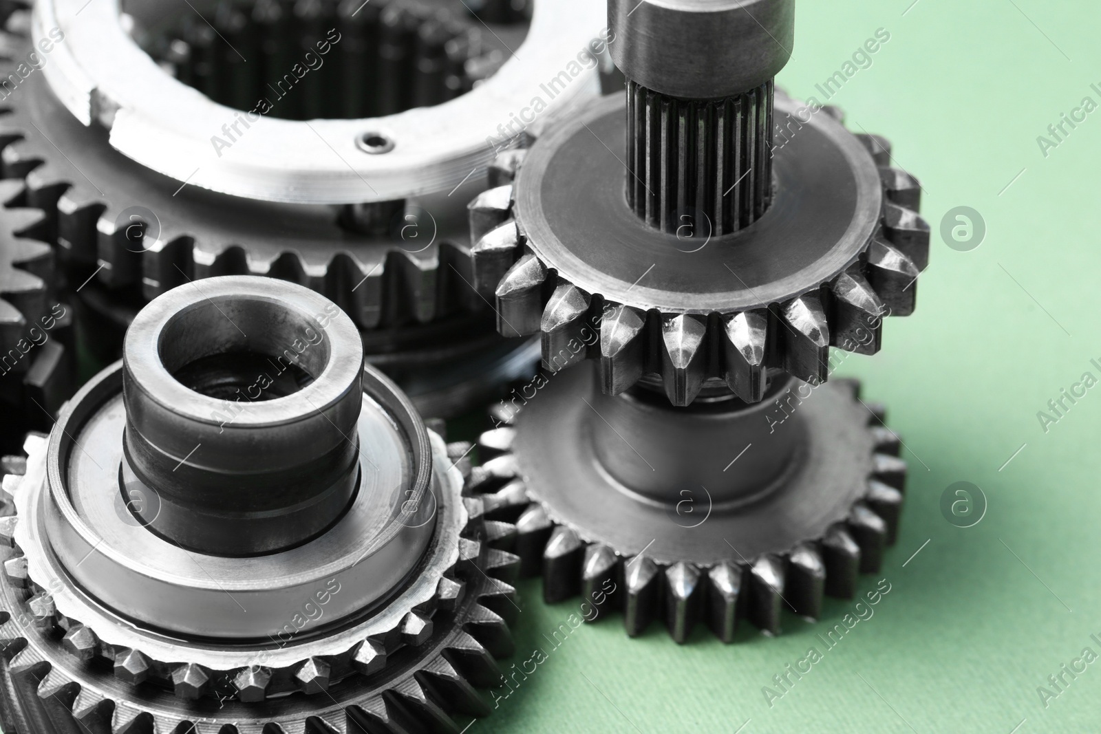 Different stainless steel gears on light green background, closeup Photo of Different stainless steel gears on light green background, closeup