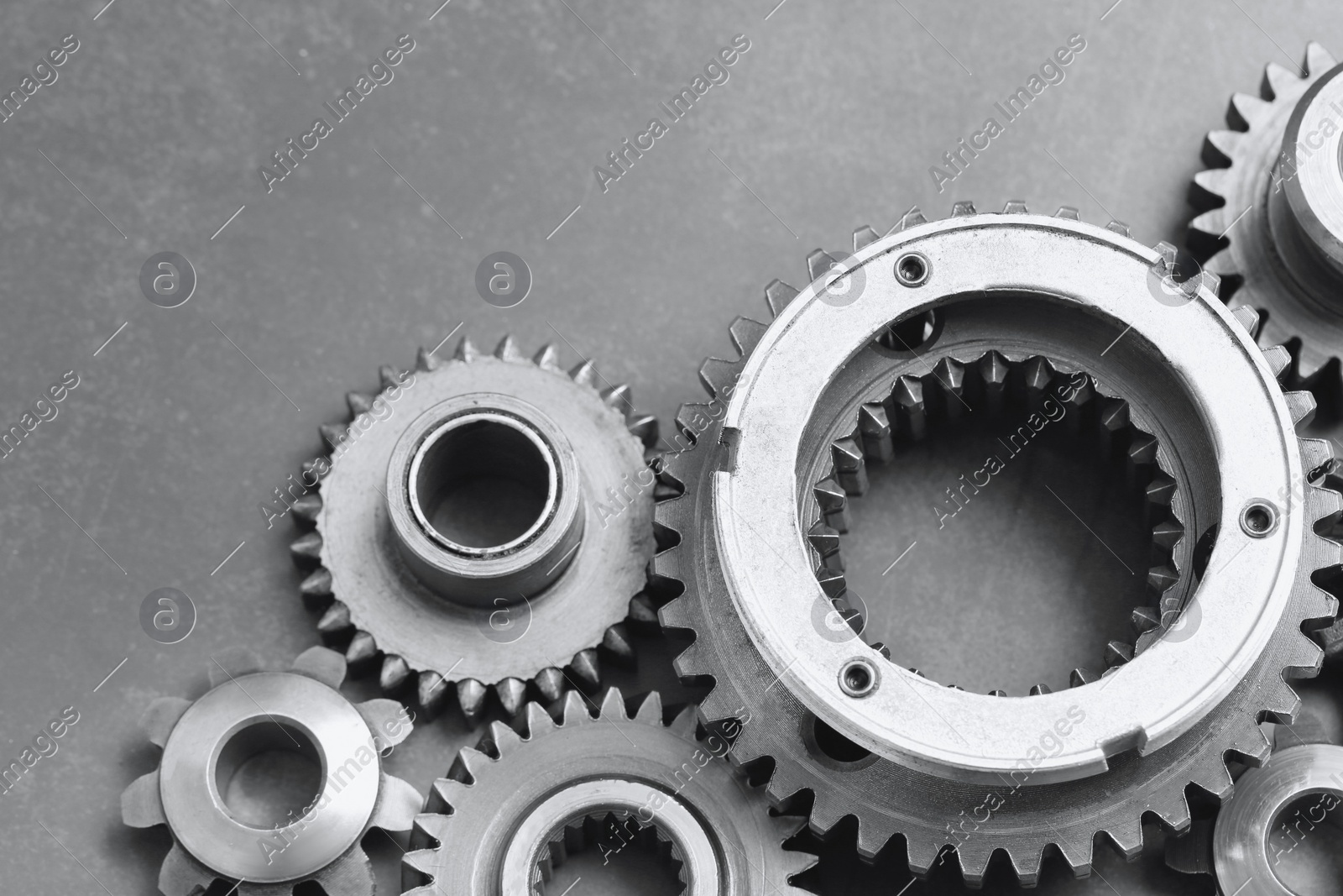 Different stainless steel gears on grey background, closeup. Space for text Photo of Different stainless steel gears on grey background, closeup. Space for text