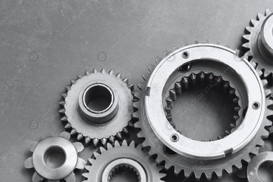 Different stainless steel gears on grey background, closeup. Space for text Photo of Different stainless steel gears on grey background, closeup. Space for text
