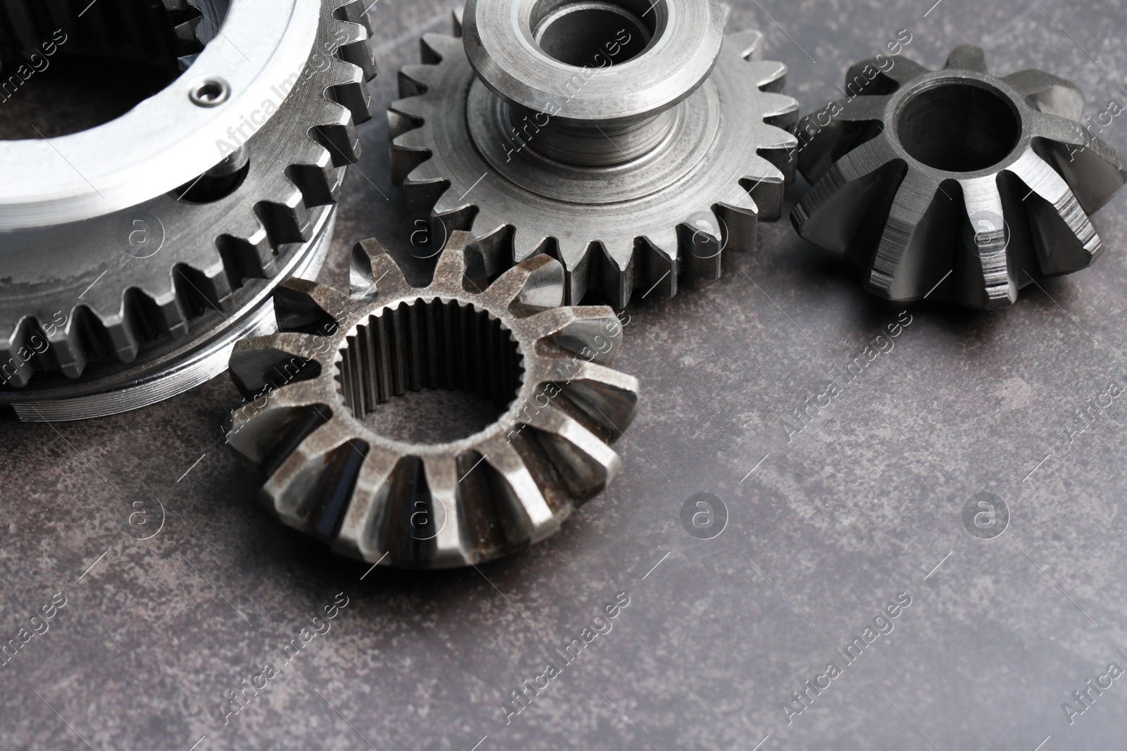 Different stainless steel gears on grey background. Space for text Photo of Different stainless steel gears on grey background. Space for text