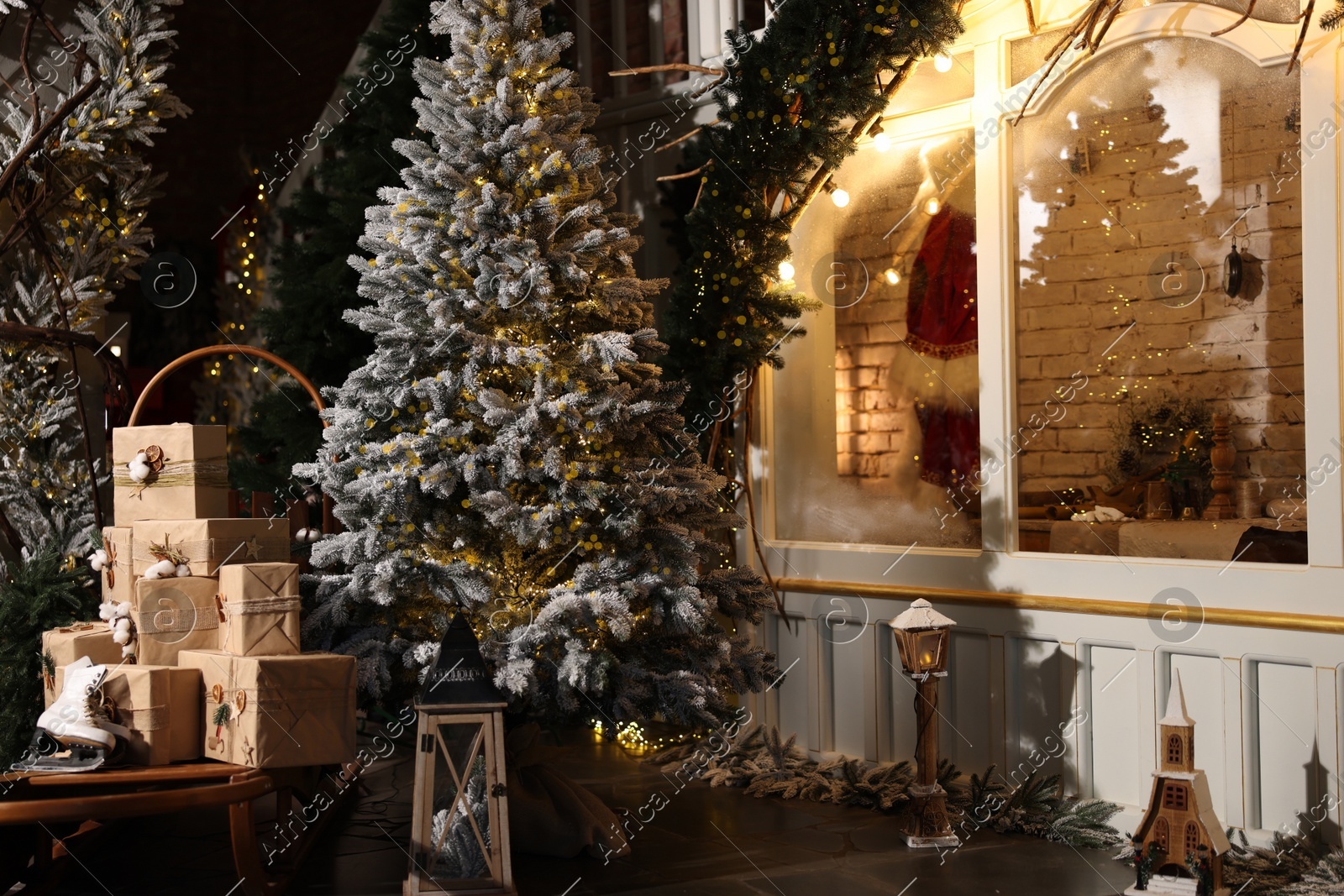 Beautiful Christmas trees, gift boxes, skates and festive decor indoors. Interior design Photo of Beautiful Christmas trees, gift boxes, skates and festive decor indoors. Interior design