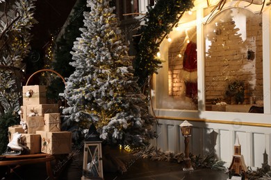 Beautiful Christmas trees, gift boxes, skates and festive decor indoors. Interior design Photo of Beautiful Christmas trees, gift boxes, skates and festive decor indoors. Interior design