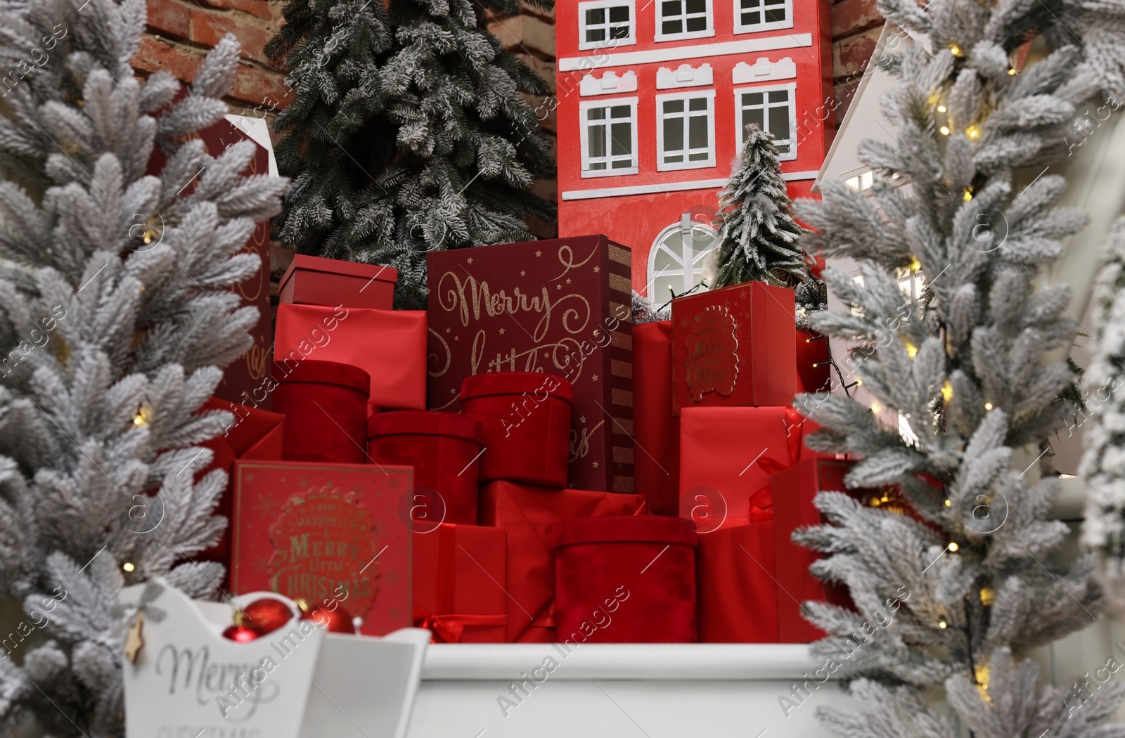 Christmas trees, gift boxes and festive decor indoors. Interior design Photo of Christmas trees, gift boxes and festive decor indoors. Interior design