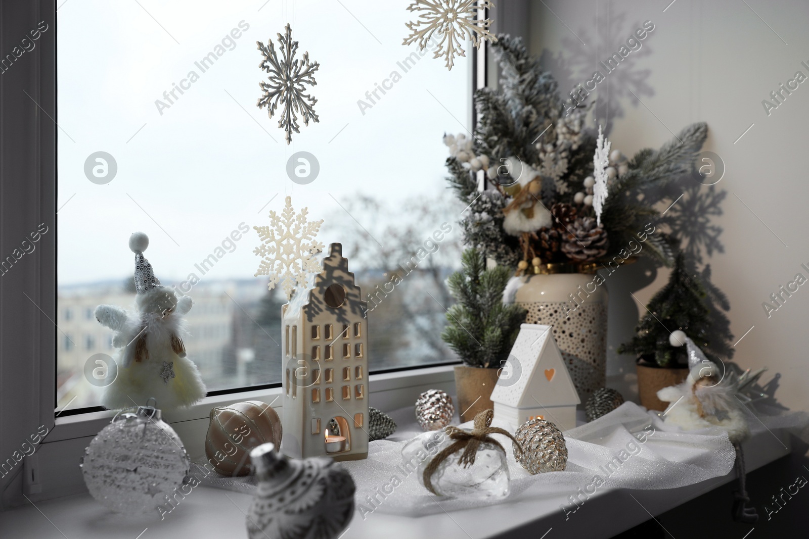 Many beautiful Christmas decorations and fir trees on window sill indoors Photo of Many beautiful Christmas decorations and fir trees on window sill indoors