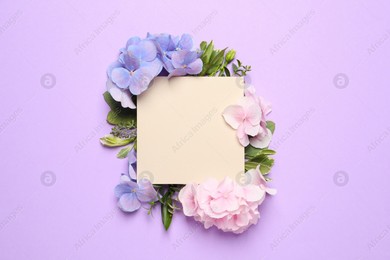 Beautiful hortensia flowers and blank card on violet background, flat lay. Space for text Photo of Beautiful hortensia flowers and blank card on violet background, flat lay. Space for text