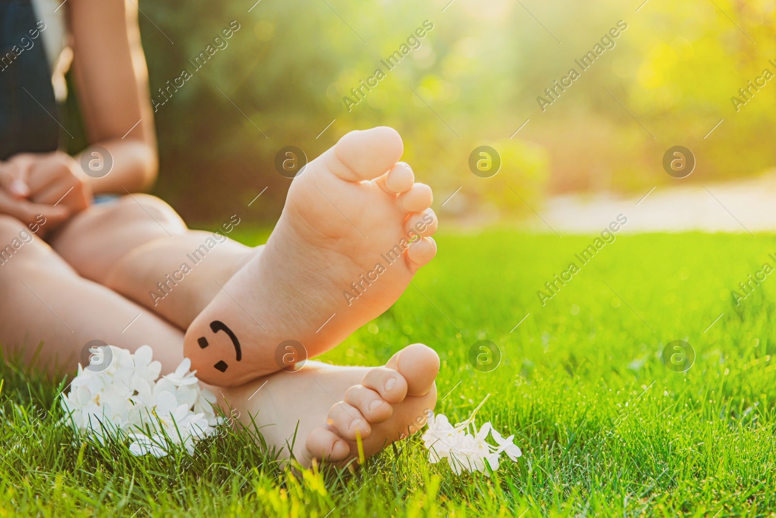 Teenage girl with beautiful hortensia flowers and smiling face drawn on heel outdoors, closeup. Space for text Photo of Teenage girl with beautiful hortensia flowers and smiling face drawn on heel outdoors, closeup. Space for text