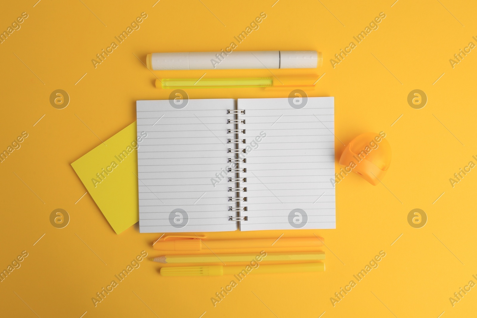 Flat lay composition with open notebook and different school stationery on yellow background, space for text. Back to school Photo of Flat lay composition with open notebook and different school stationery on yellow background, space for text. Back to school