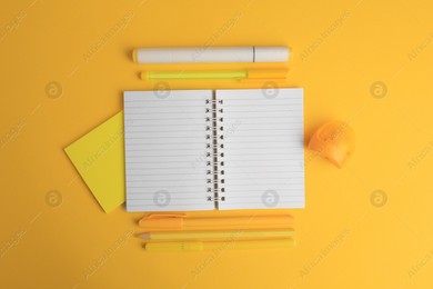 Flat lay composition with open notebook and different school stationery on yellow background, space for text. Back to school Photo of Flat lay composition with open notebook and different school stationery on yellow background, space for text. Back to school