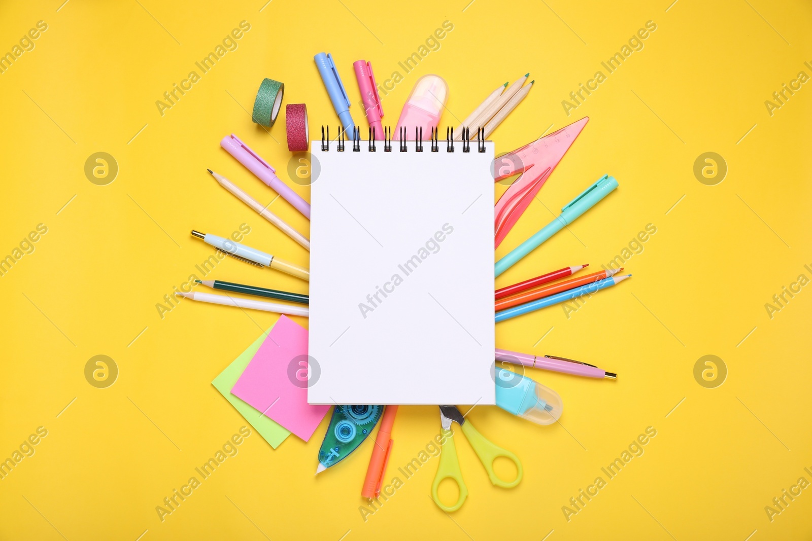 Flat lay composition with blank notebook and different school stationery on yellow background, space for text. Back to school Photo of Flat lay composition with blank notebook and different school stationery on yellow background, space for text. Back to school