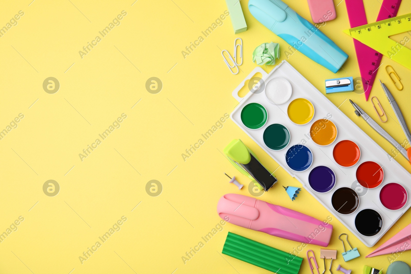 Flat lay composition with different school stationery on pale yellow background, space for text. Back to school Photo of Flat lay composition with different school stationery on pale yellow background, space for text. Back to school