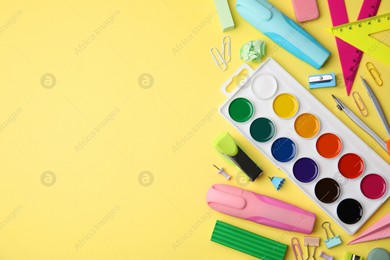 Flat lay composition with different school stationery on pale yellow background, space for text. Back to school Photo of Flat lay composition with different school stationery on pale yellow background, space for text. Back to school