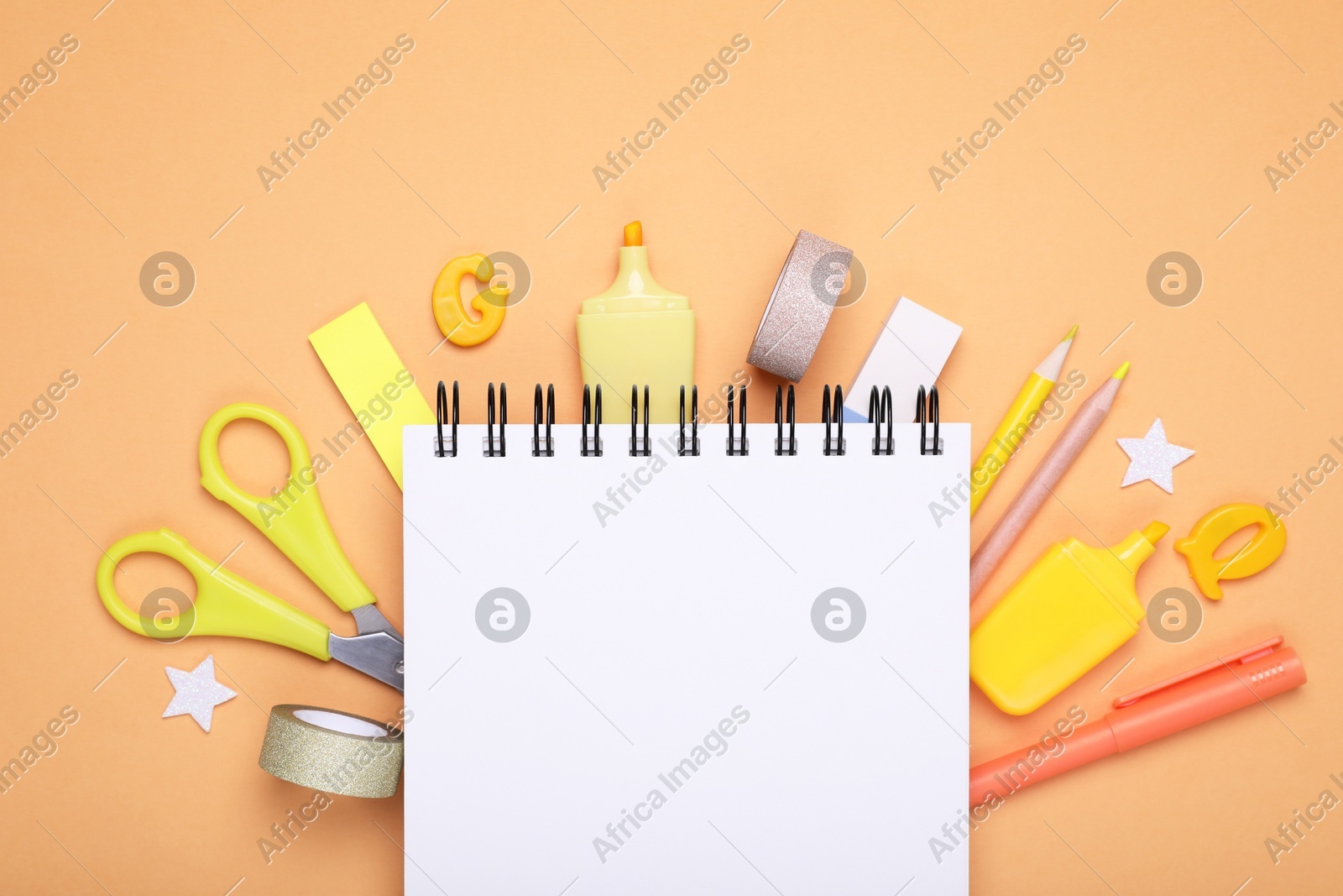 Flat lay composition with notebook and other school stationery on orange background, space for text. Back to school Photo of Flat lay composition with notebook and other school stationery on orange background, space for text. Back to school