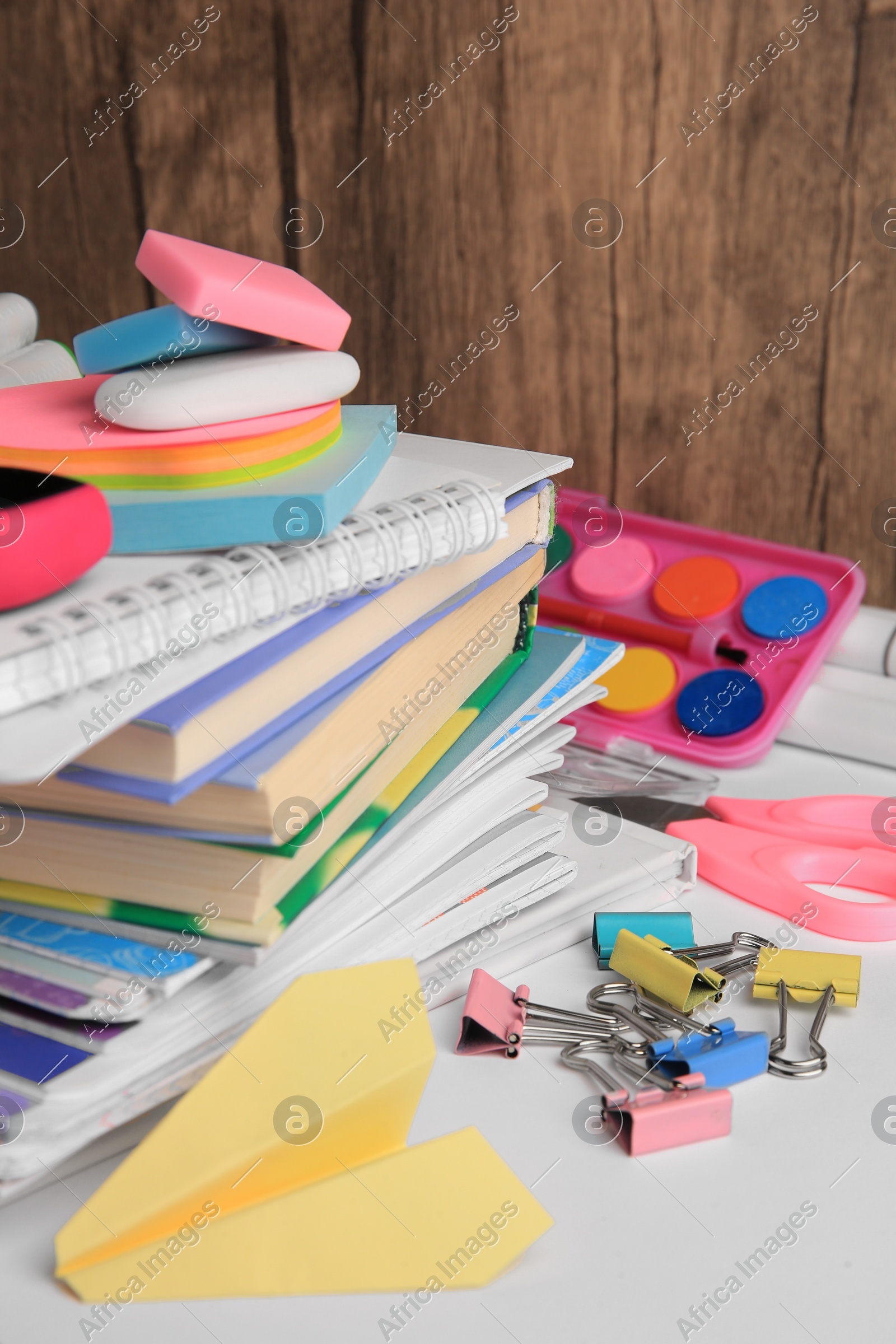 Many different books, paper plane and school stationery on white table. Back to school Photo of Many different books, paper plane and school stationery on white table. Back to school
