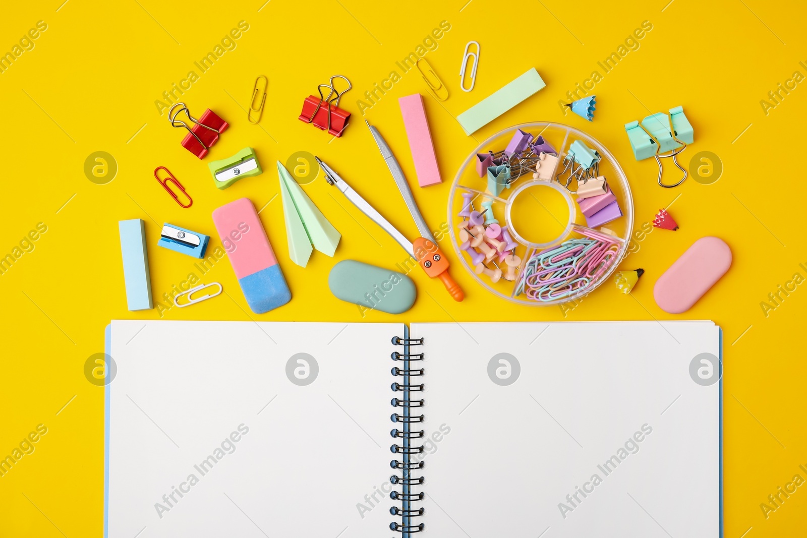 Flat lay composition with notebook and different school stationery on yellow background. Back to school Photo of Flat lay composition with notebook and different school stationery on yellow background. Back to school
